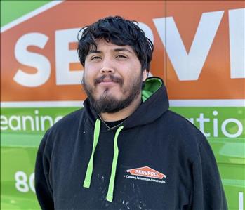 Male SERVPRO employee in front of green background