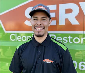 Male SERVPRO employee in front of green background