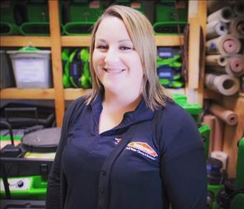 Katy Driscoll standing in front of servpro equipment on shelf