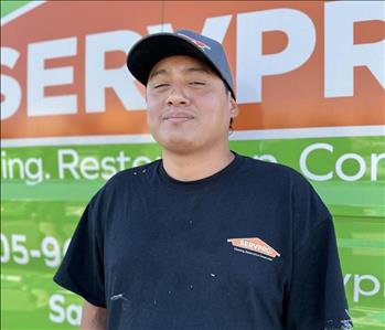 Male SERVPRO employee in front of green background