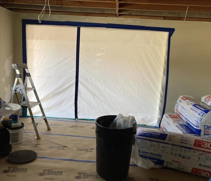Inside of a home with construction supplies and a plastic covering to prepare for the start of construction