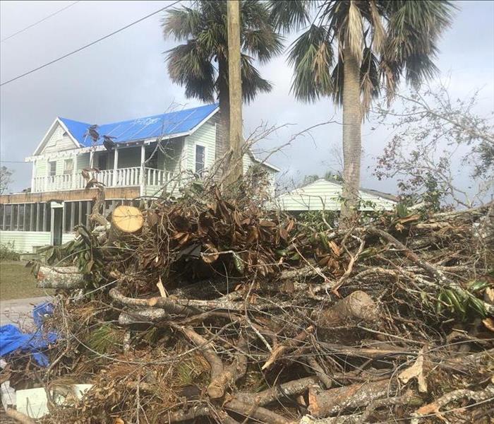 Storm debris piled in front of a home